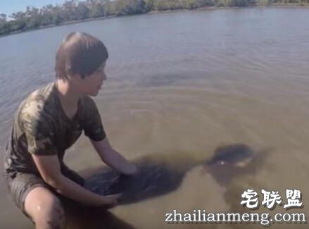 小孩海边玩耍时在水中发现鲨鱼,没想到竟然赤手空拳把它抓起!